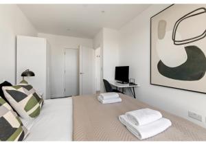 贝肯翰姆Beckenham Beauty: Modern 1-Bedroom Abode的白色卧室配有床和书桌