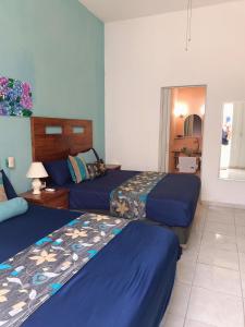 巴亚尔塔港Casa las Flores的酒店客房,配有两张带蓝色床单的床
