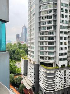 吉隆坡Summer suites KLCC by cozy stay的享有高高的白色建筑和绿色屋顶的景色