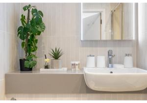 贝肯翰姆Sophisticated Living: 1-BR Flat in Beckenham的浴室设有水槽、镜子和植物