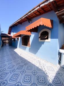 蒙加瓜Casa em Mongaguá Plataforma的前面有瓷砖地板的蓝色建筑