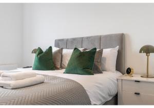 贝肯翰姆Cosmopolitan Living: Upscale 1BR Gem in Beckenham的一间卧室配有一张带绿色枕头的大床