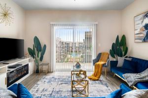 休斯顿BRAND NEW Luxurious, Spacious, Gated 2bd Apt的客厅配有蓝色的沙发和电视