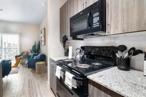 休斯顿BRAND NEW Luxurious, Spacious, Gated 2bd Apt的厨房配有炉灶和微波炉。