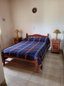 乌玛瓦卡Cabañas Kurmi的卧室内的一张床位,配有2个床头柜和2盏灯