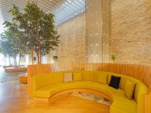 仙台The OneFive Sendai的砖墙房间里一张黄色的沙发