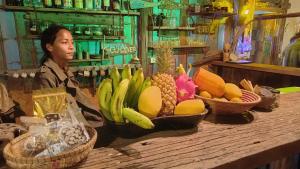 象岛Seree Bungalows的坐在桌子上的女人,上面有水果