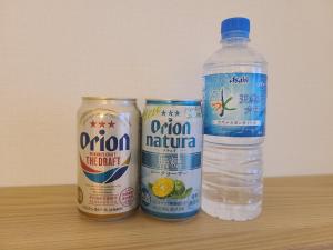 那霸Orion Hotel NAHA的桌子上放一瓶水和两罐水