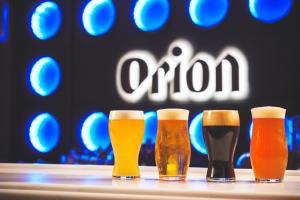 那霸Orion Hotel NAHA的 ⁇ 头前桌上的四杯啤酒