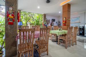 库塔库塔雅旅馆的一间带绿色桌椅的用餐室