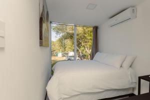 Mangoya Lounge的卧室配有白色的床和窗户。
