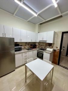 马拉喀什Appartement de luxe Marrakech Menara的厨房配有白色橱柜和白色桌子