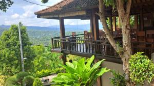 姆杜克巴厘岛拉哈优民宿的一座带森林景阳台的建筑