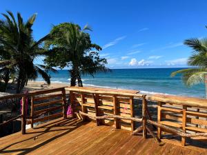 喀巴里特Beach Cabarete Lodge Eco De Luxe Surf, Kite, Yoga的享有海滩景致的木制甲板