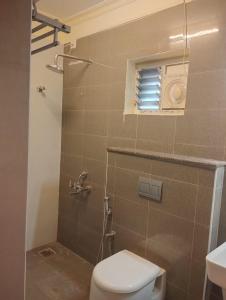 钦奈A.R Residency的一间带卫生间和淋浴及窗户的浴室