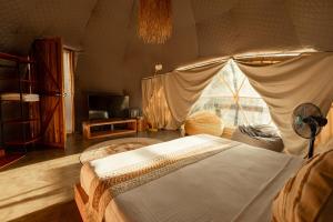 爱妮岛Domes and Dreams Lio Glamping的一间卧室配有一张大床和帐篷