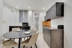 巴黎Comfortable apartment Marx Dormoy的厨房以及带桌椅的用餐室。