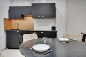 巴黎Comfortable apartment Marx Dormoy的厨房配有黑色桌子,上面有白色的盘子
