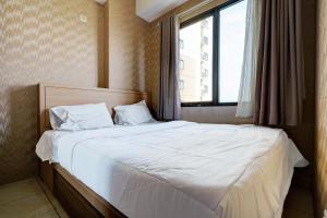 万隆OYO Life 93310 Apartemen Tamansari Panoramic By Santuy 2的卧室配有一张大白色床和窗户
