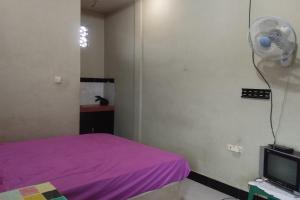 TjakranegaraOYO Life 93403 Penginapan Adinda的一间卧室配有一张紫色的床和一个风扇