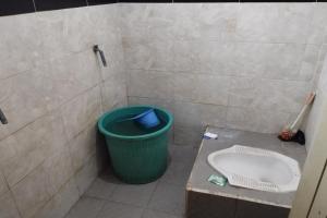 TjakranegaraOYO Life 93403 Penginapan Adinda的浴室设有绿色垃圾箱和水槽