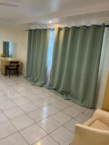 达累斯萨拉姆Mikocheni smart apartment的客厅配有绿色窗帘和桌子