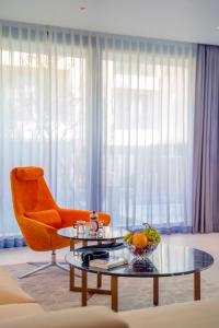 会安The Five Villas & Resort Quangnam - Danang的客厅配有橙色椅子和玻璃桌