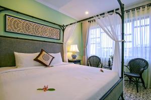 会安Hoi An Town Home Resort的一间卧室配有一张带白色床罩的床
