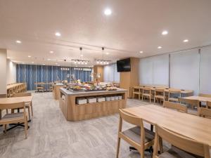 厚木HOTEL MYSTAYS Atsugi的一间带桌椅的餐厅以及一间自助餐