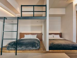 东京illi Mani Shibuya的小型客房配有2张双层床和1张床