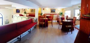 维亚雷焦凯蒂酒店的餐厅设有红色的沙发、桌子和椅子
