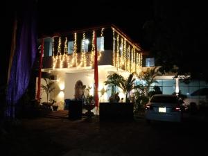 TanamalwilaTharuka Rest Inn Hotel的夜间用圣诞灯点亮的房子