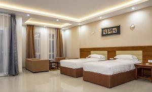 塞拉莱RED-5 - AL Safa Suites的酒店客房设有两张床和一张桌子。