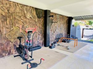 卡朗阿森Lumbung Seraya Villa的一间设有两辆健身自行车和石墙的房间