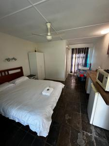 ColosseumColosseum Creek Motel的卧室配有白色的床和微波炉