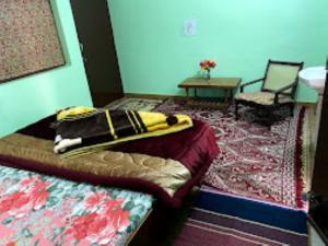 乔斯希马特YATRA HOMESTAY Joshimath的一间卧室配有一张床、一张桌子和一张地毯。
