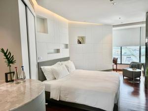曼谷曼谷利特酒店的卧室配有白色的床和书桌