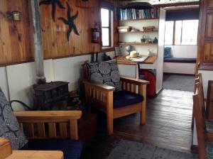 克尼斯纳Knysna Houseboat Myrtle的客厅配有炉灶、椅子和桌子
