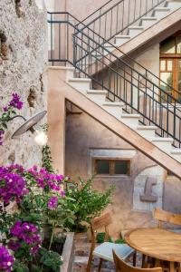 干尼亚奥夫酒店的一个带鲜花、桌子和楼梯的庭院