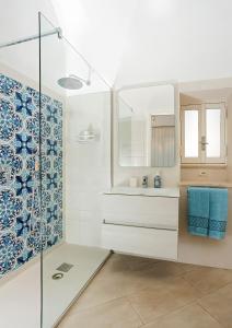 阿纳卡普里Caprita Guest House的一间带水槽和玻璃淋浴的浴室