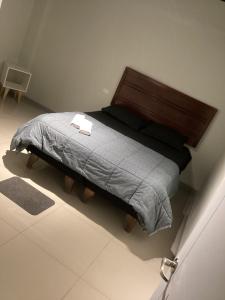 圣地亚哥Hostal low cost的卧室内的一张带木制床头板的床