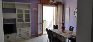 里米尼APPARTAMENTI RIMINI NEL CUORE的一间拥有紫色墙壁和桌椅的用餐室