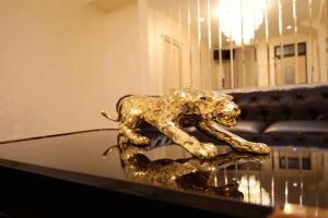 塞凡LOUVRE HOME的狮子的金雕,放在玻璃桌上