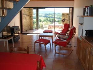 RégatGîte du Tarbésou的客厅配有红色椅子和桌子