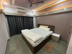 印多尔Leela Homestay Indore - Tulip - 2 BHK Luxury apartment的一间小卧室,配有一张带天花板的床