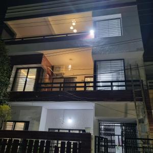 印多尔Leela Homestay Indore - Tulip - 2 BHK Luxury apartment的享有房子的景色,晚上设有阳台