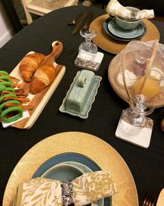 Triac-LautraitBelle Chambre的黑桌,上面有食物和面包盘