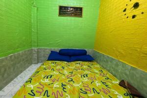TjakranegaraOYO Life 93401 Kos Putri Alamanda Syariah的一间小卧室,在绿色的墙上配有一张床
