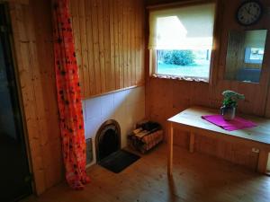 RannakülaHide in the nature – cozy lakeside saunacottage的小房间设有桌子和壁炉