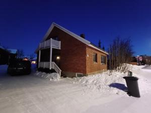 基律纳Kiruna accommodation Läraregatan 19 b的夜晚有雪覆盖的房子
